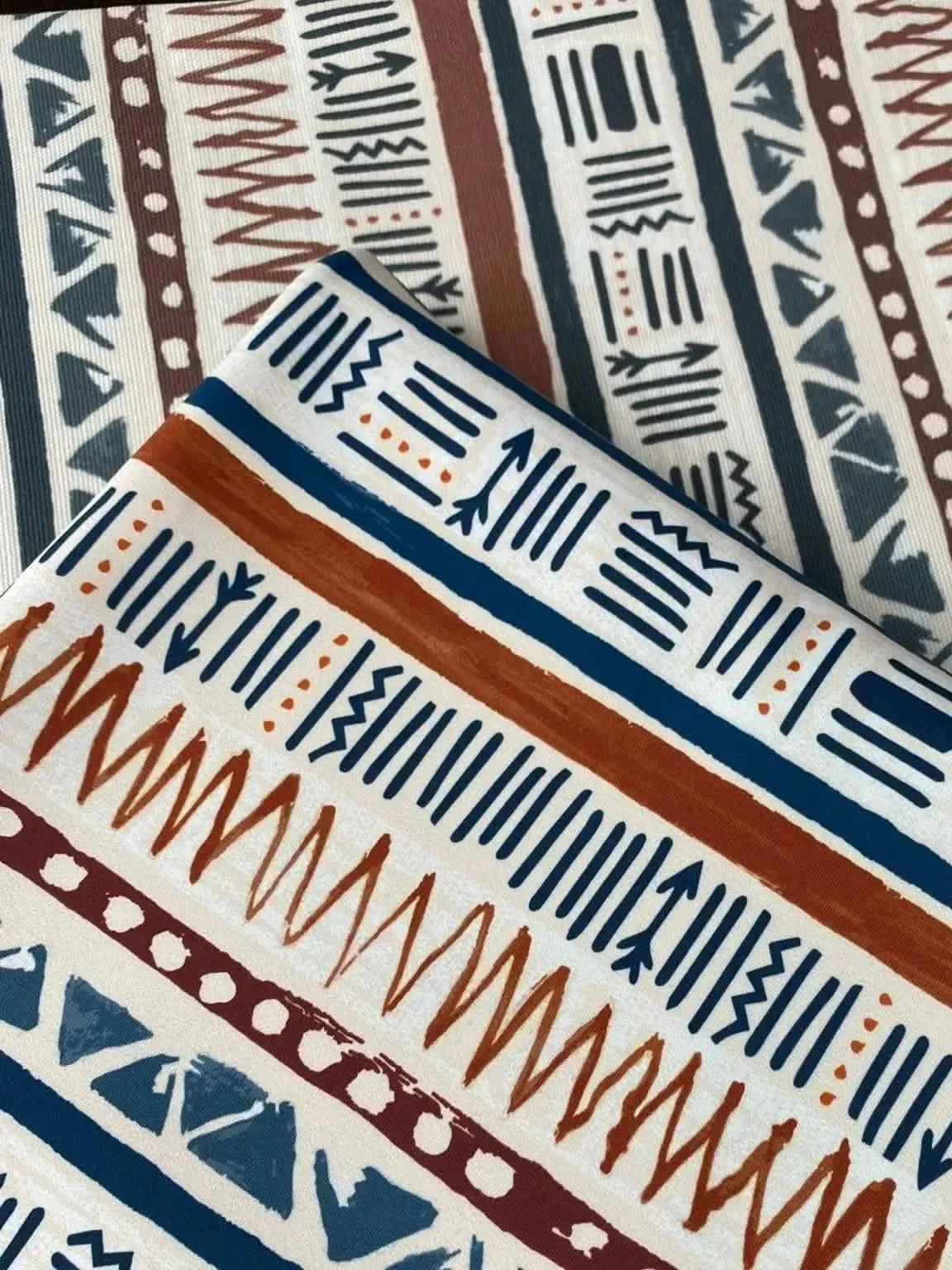 Two pieces of fabric with a tribal pattern in blue, brown, and white.