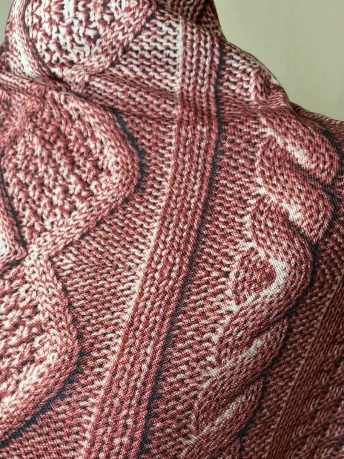 Rose cable knit fabric with white and dark brown accents.