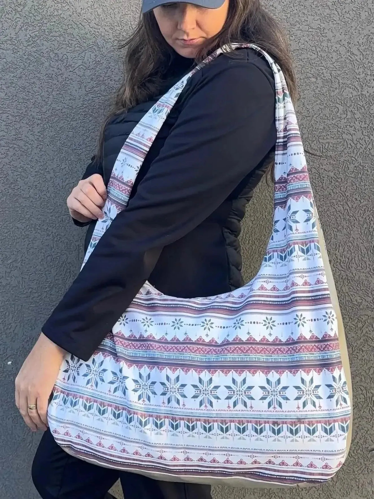 A woman models a tote bag sewn from WayMaker Fabrics Frosted Fair Isle Snowflake Winter fabric with white and pink snowflake patterns.