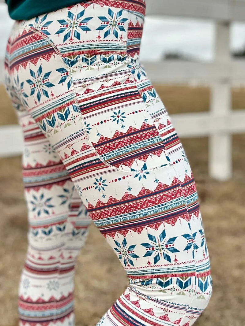 A person wearing Frosted patterned leggings with a white fence in the background.
