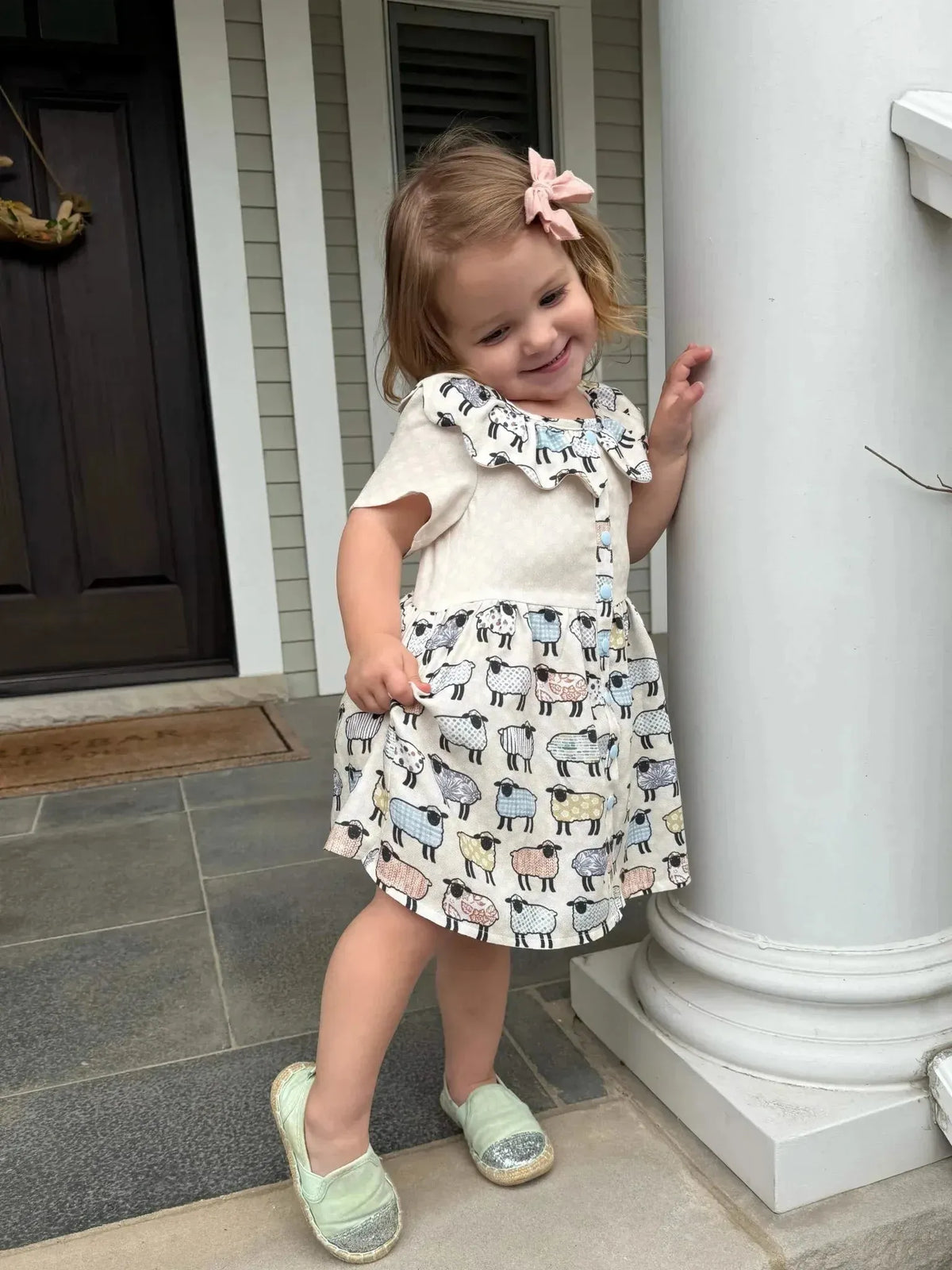 Patchwork sheep print craft fabric with colorful sheep motifs on a white background.