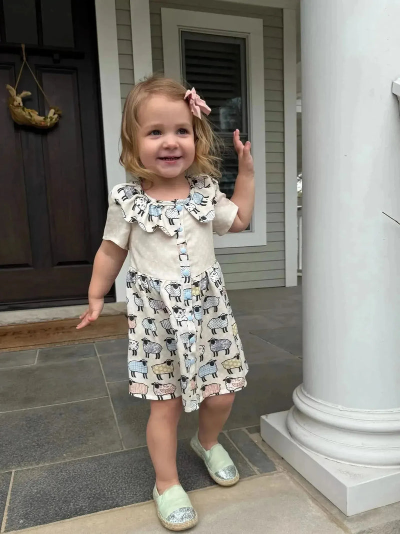 Patchwork sheep print craft fabric with white and gray animal motifs.