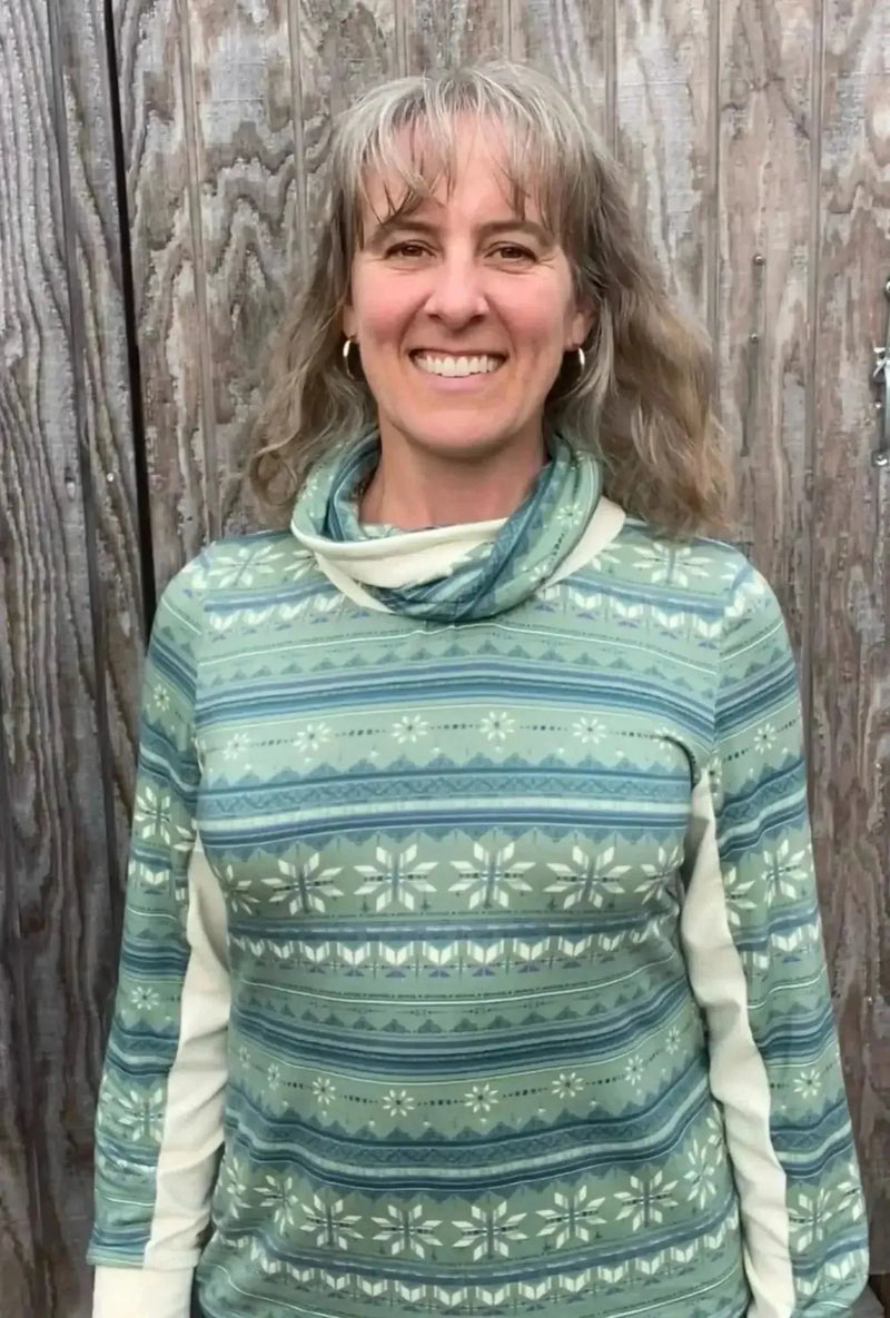 Green-blue winter snowflake print fabric with frosted forest pattern.