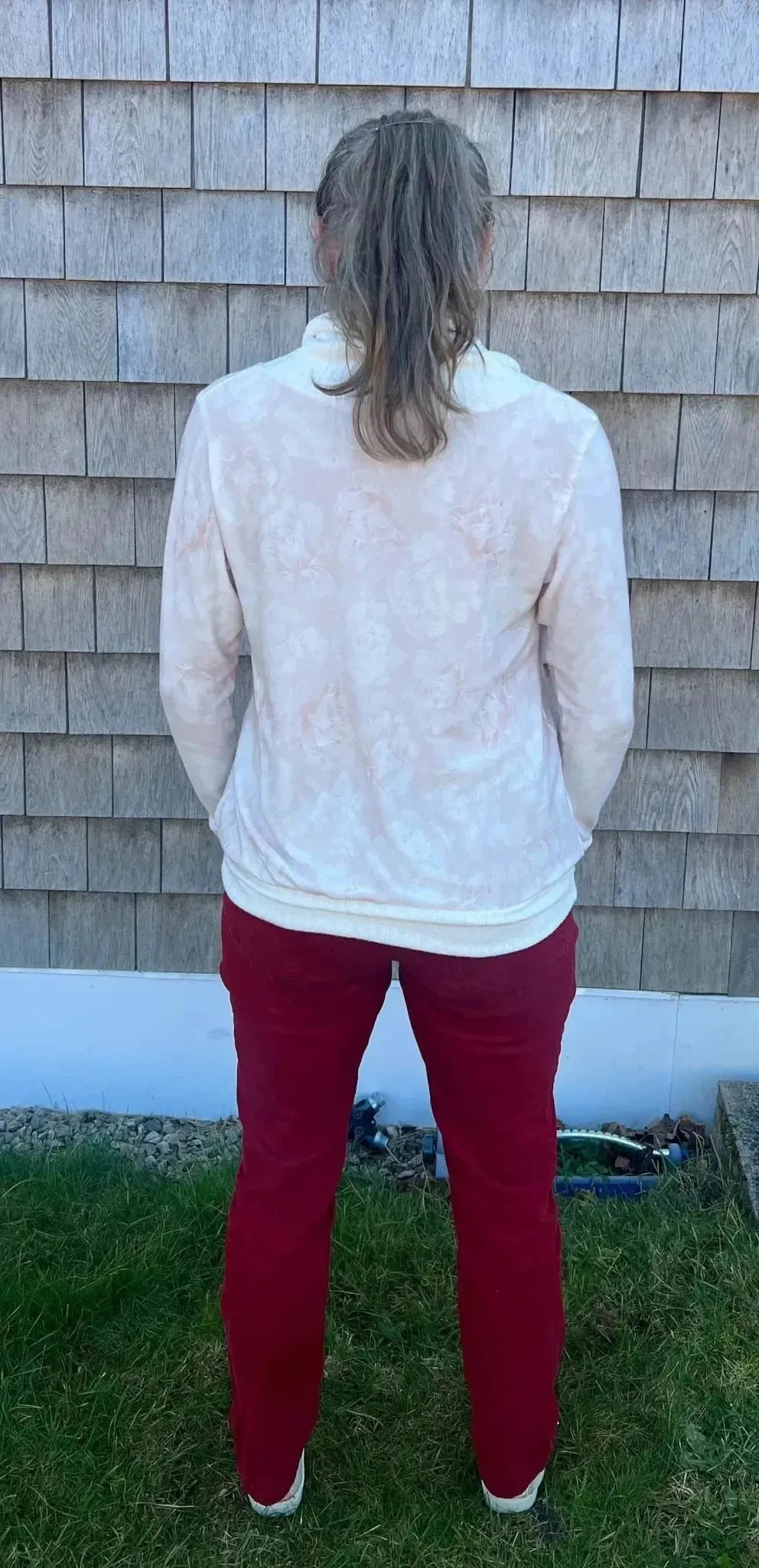 Elegant pink floral print fabric with white lace-like details on a sheer cardigan.