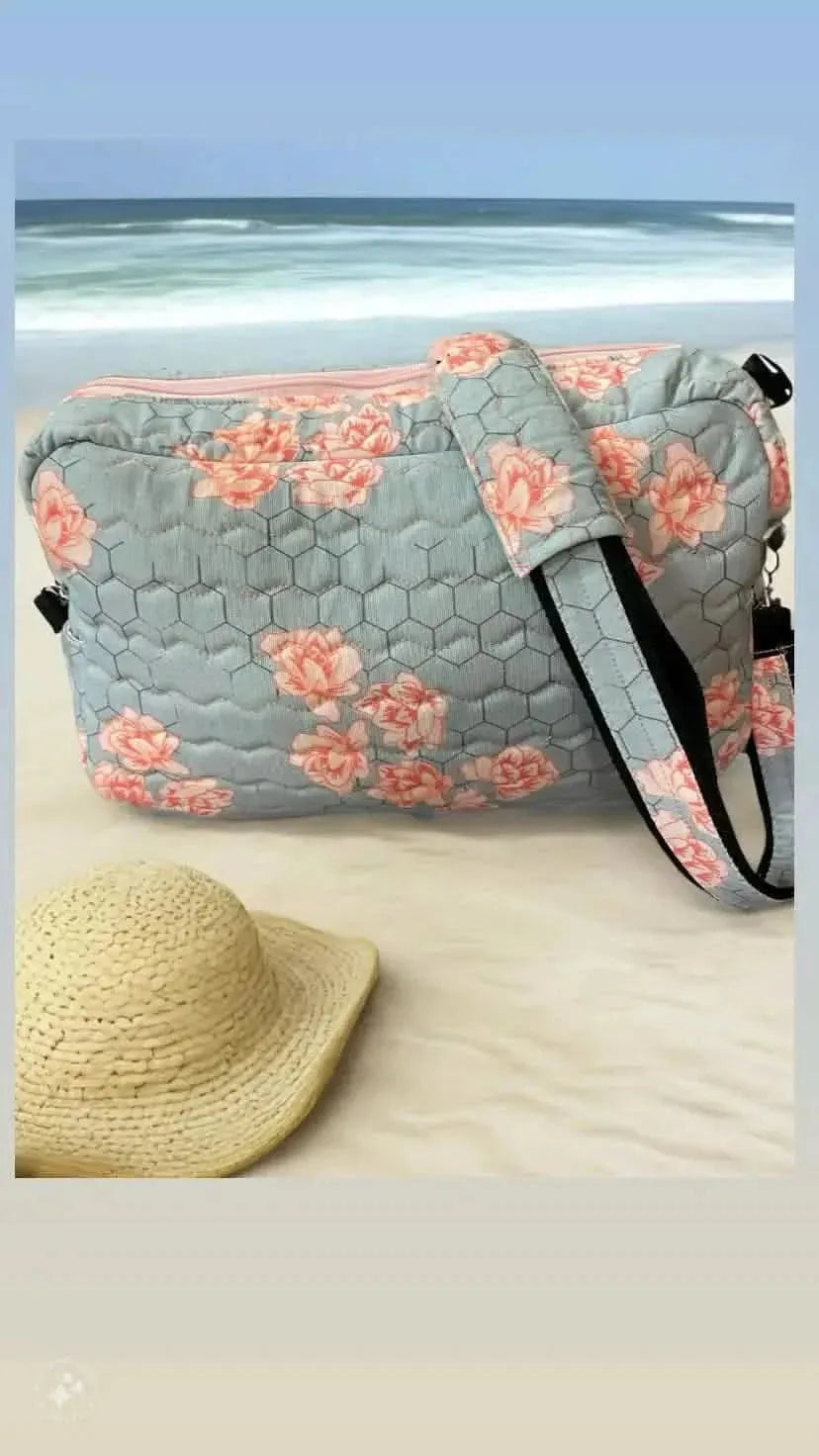 Honeycomb-patterned fabric with pink floral print on a gray background.