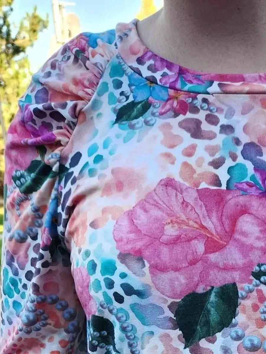 Vibrant tropical fabric with wild hibiscus floral print in pink, blue, and green.