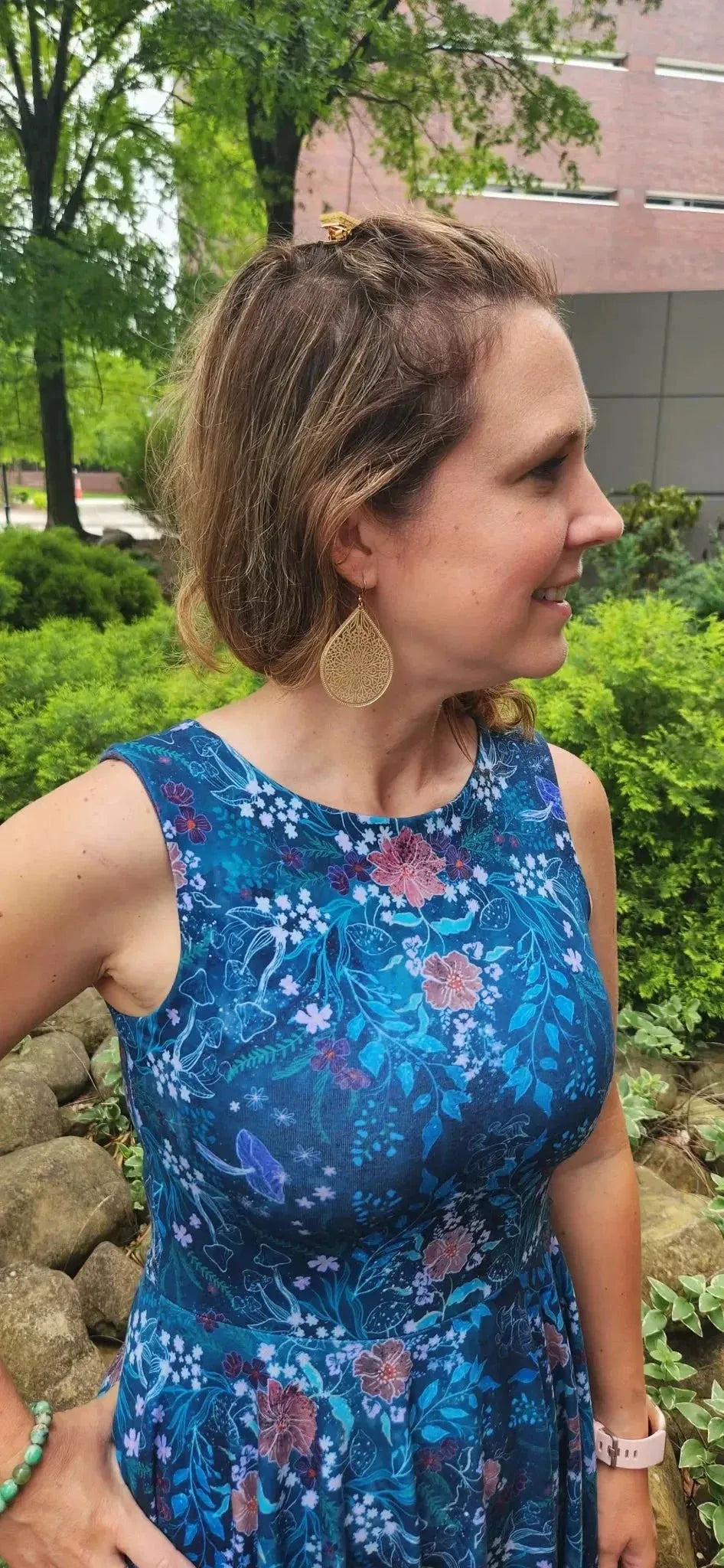 Teal woodland print fabric with enchanted glen floral pattern on blue base.