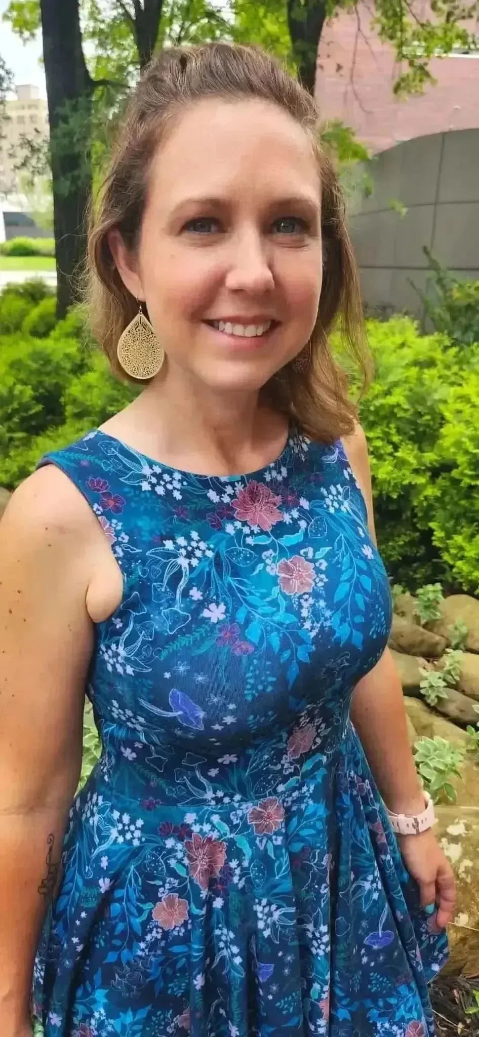 Teal woodland print fabric with enchanted glen floral pattern on blue base.