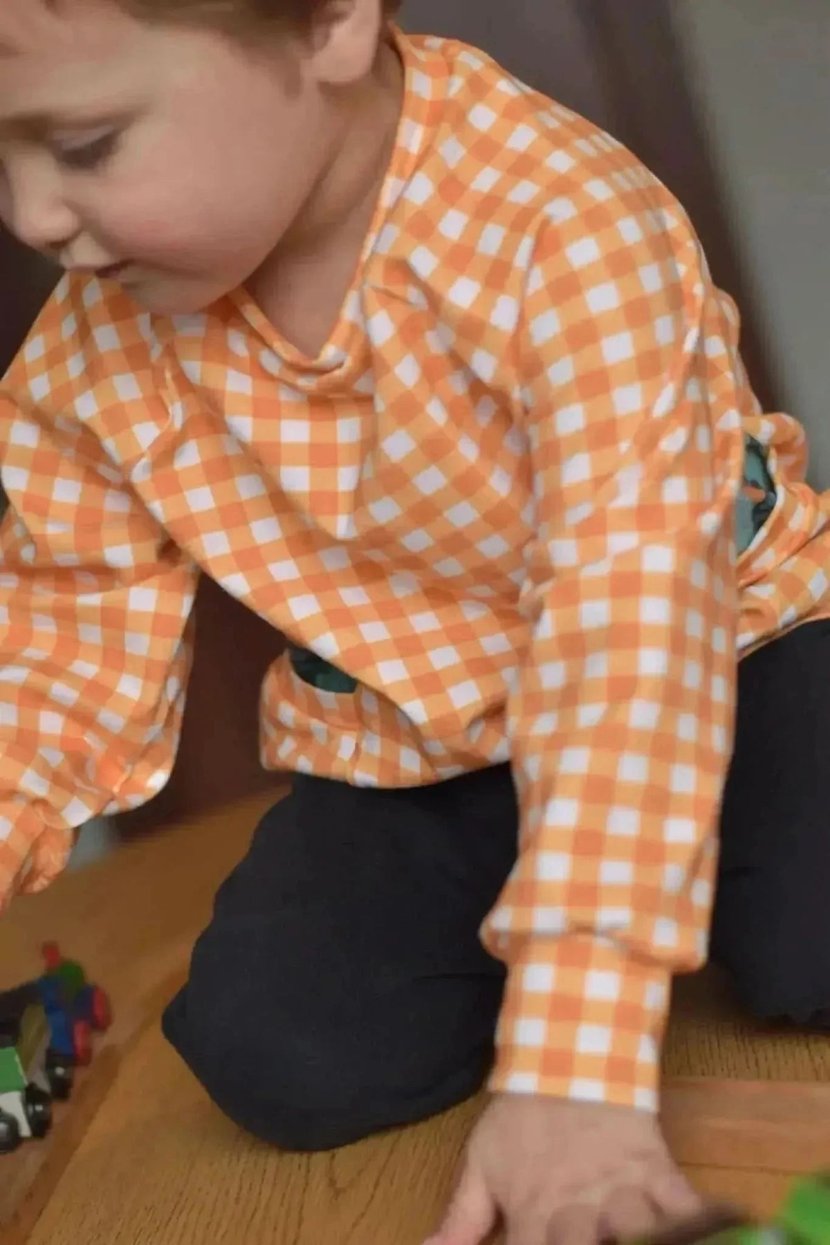 Mustard gingham checkered fabric with orange and white squares.