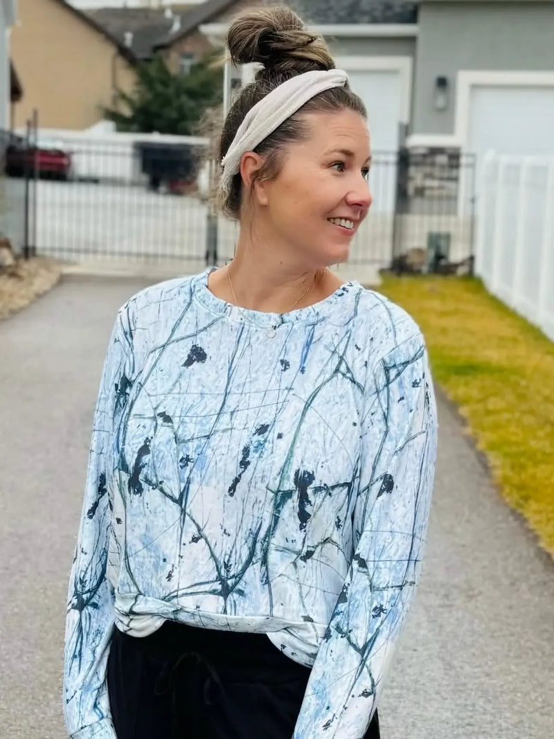 A woman wears a long-sleeved shirt with a white and blue cracked ice pattern.