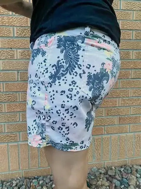 A person wears shorts with a leopard print and floral lace pattern.