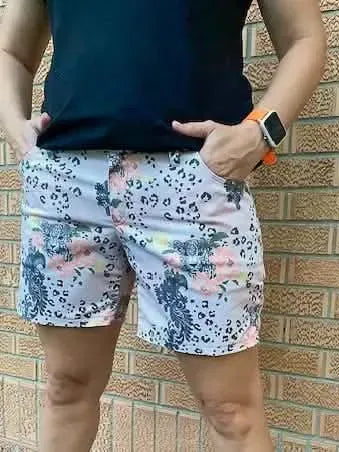 A person wears shorts with a leopard and floral print.