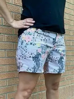 A person wears shorts with a leopard print and floral design.