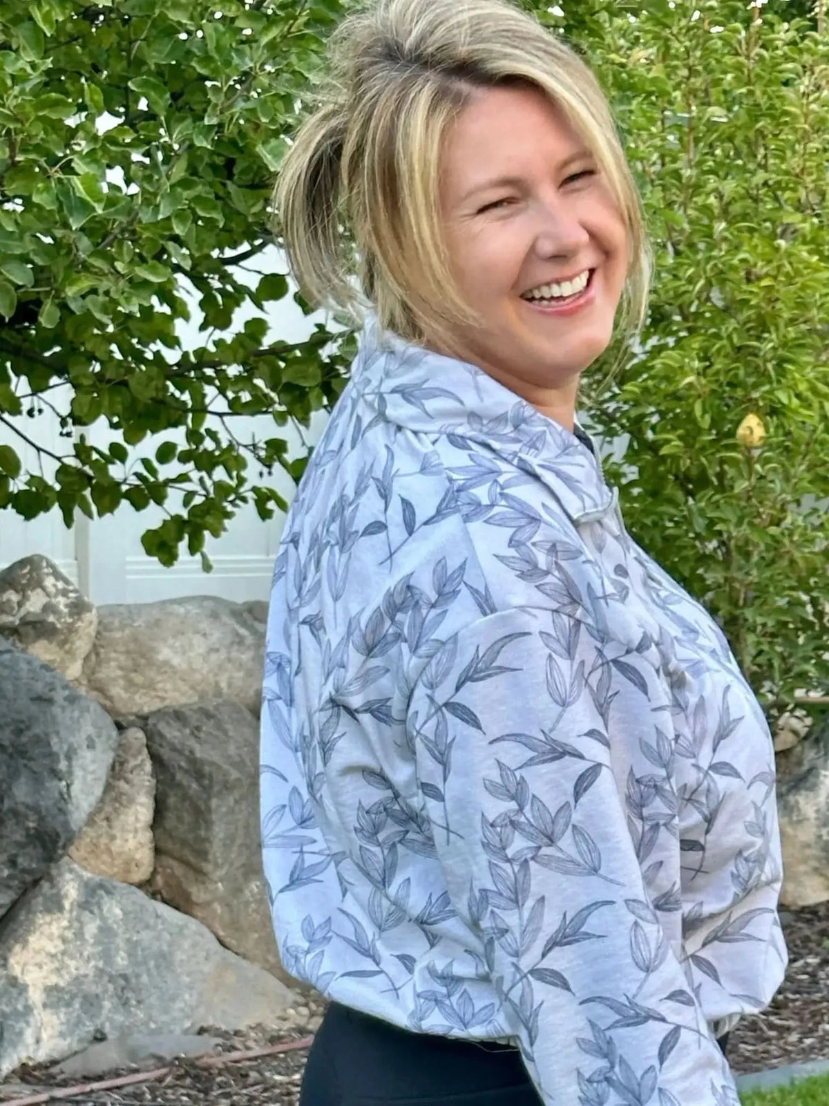 Grey foliage botanical print fabric with leaf patterns on a light background.