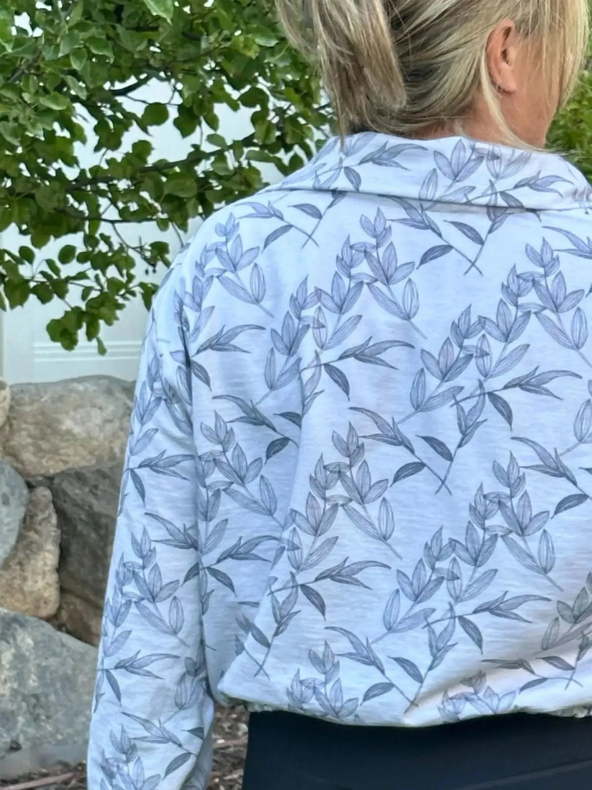 Grey foliage botanical print fabric with leaf motifs on a light background.