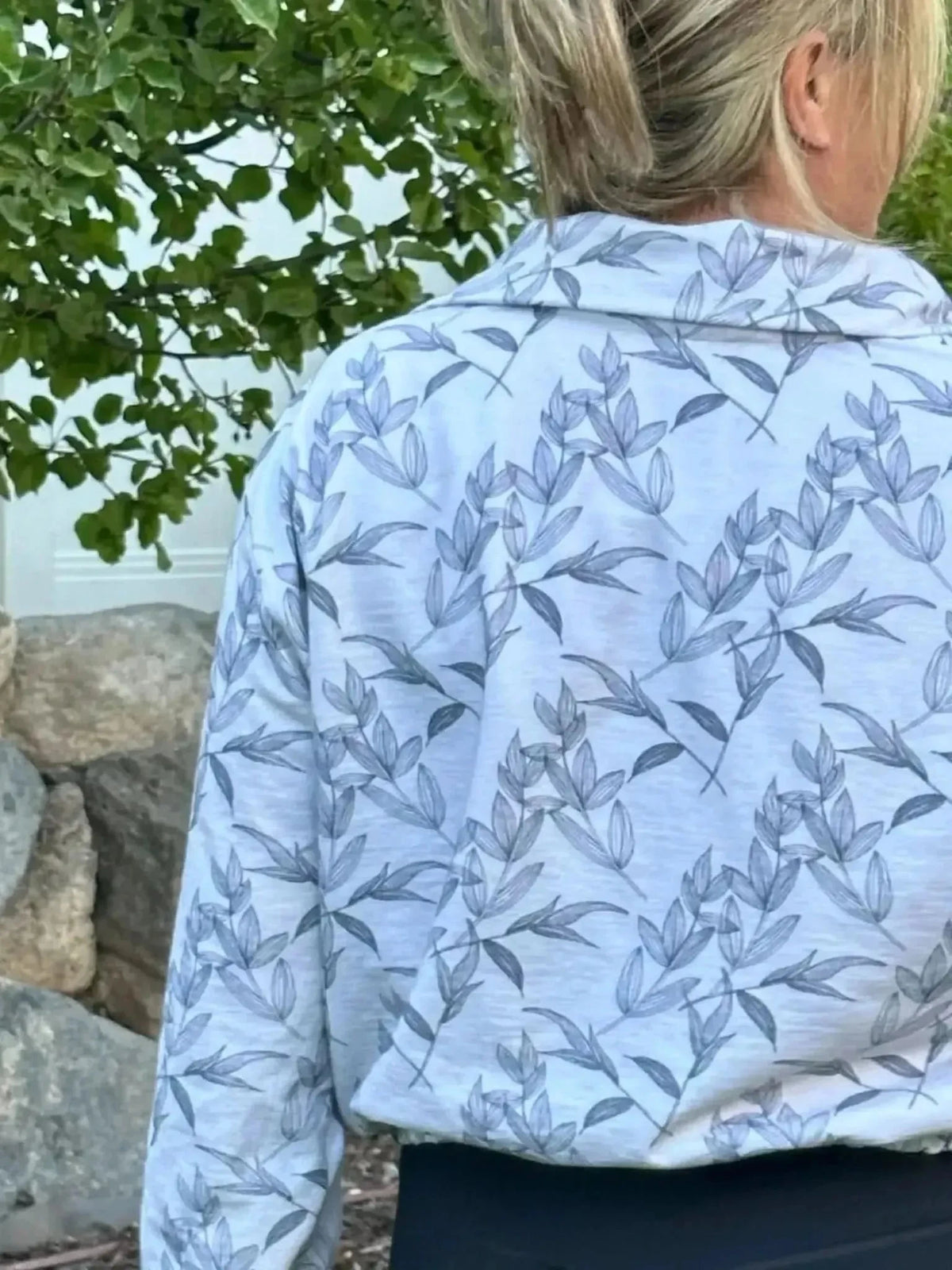 Grey foliage botanical print fabric with leaf motifs on a light background.