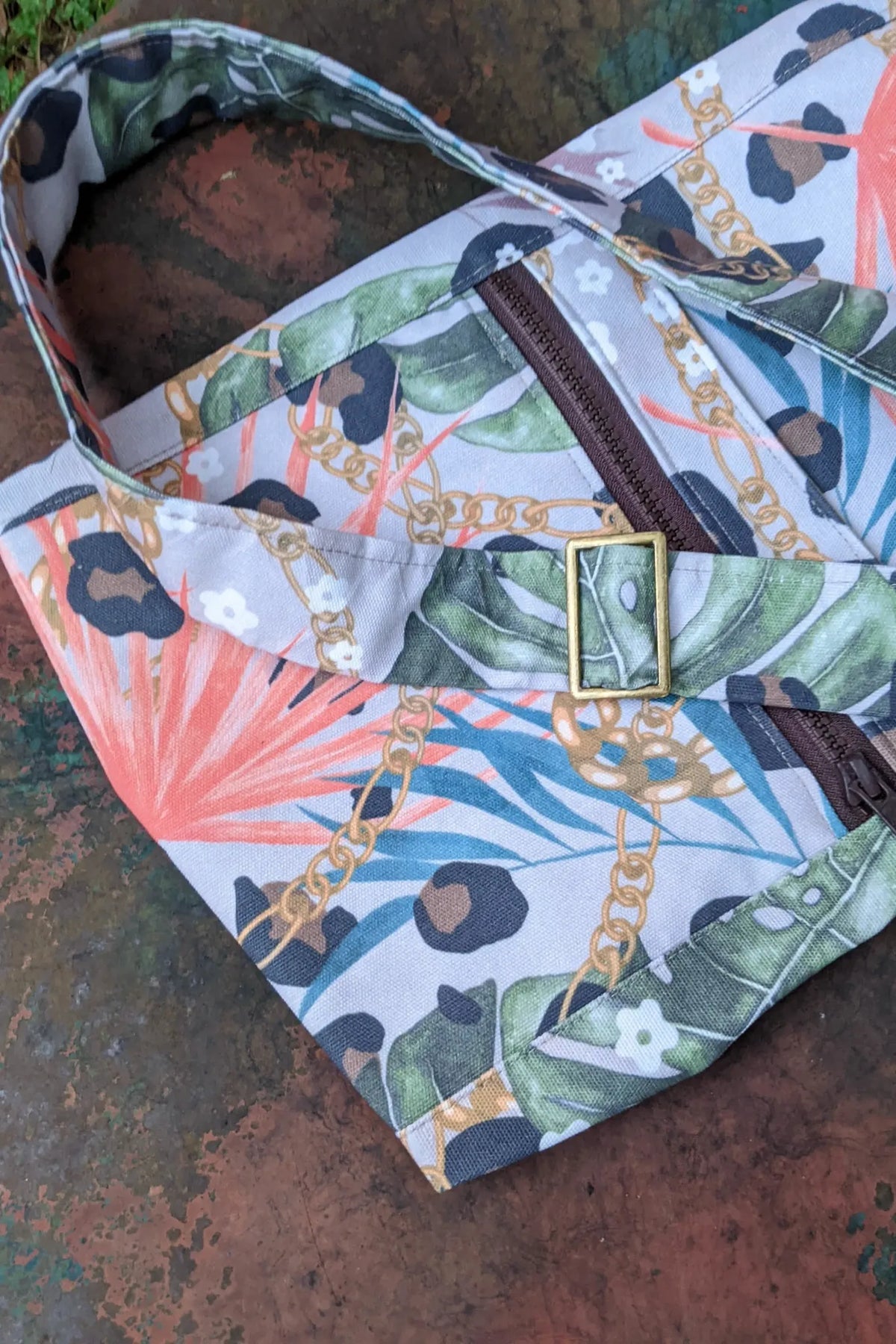 A fabric with a leopard, chain, and tropical leaf pattern.