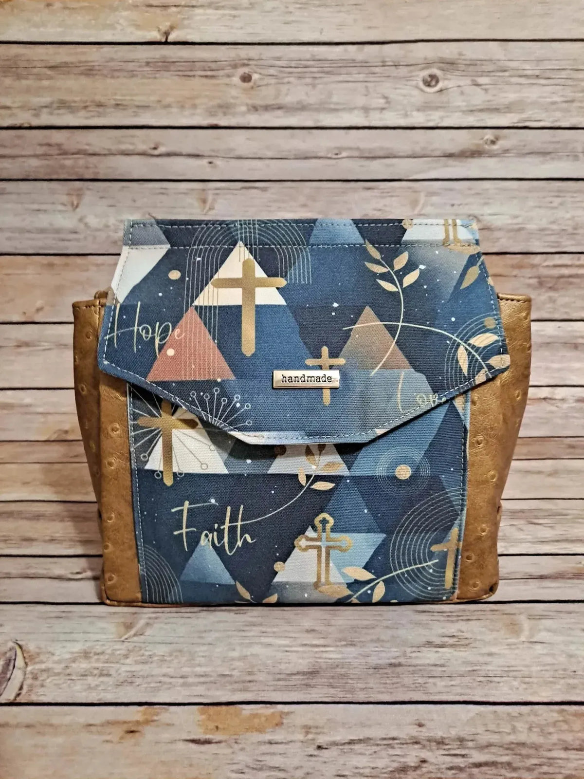 Blue geometric fabric with faith words, crosses, and leaves in navy and pink tones.
