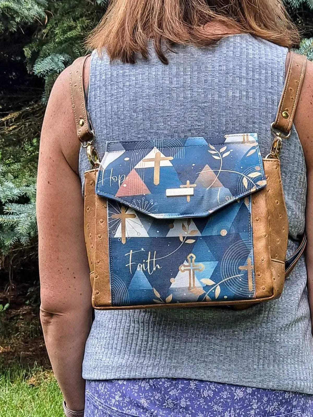 A person from behind wearing a backpack with a "Faith" design.