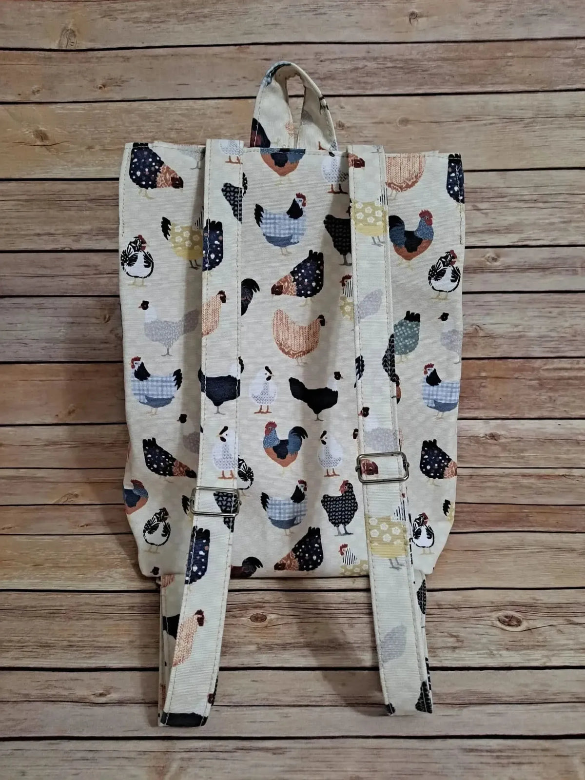 A backpack made from fabric with a colorful patchwork chicken pattern.