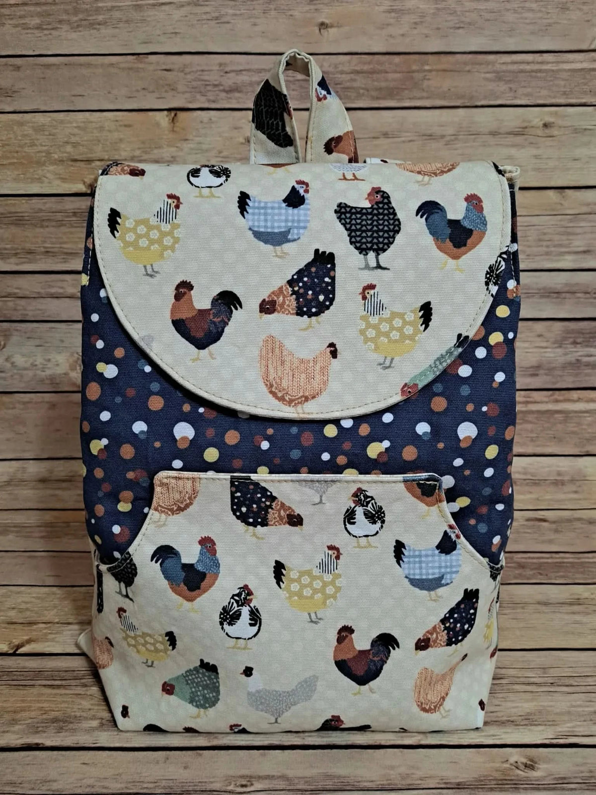 A backpack with a chicken print on a light background and a polka dot pattern on dark blue.