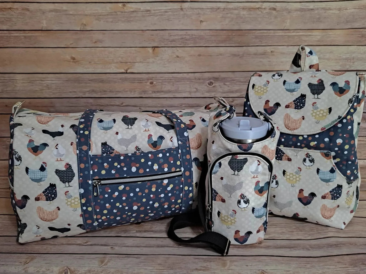 A duffel bag, water bottle holder, and backpack with a patchwork chicken pattern.