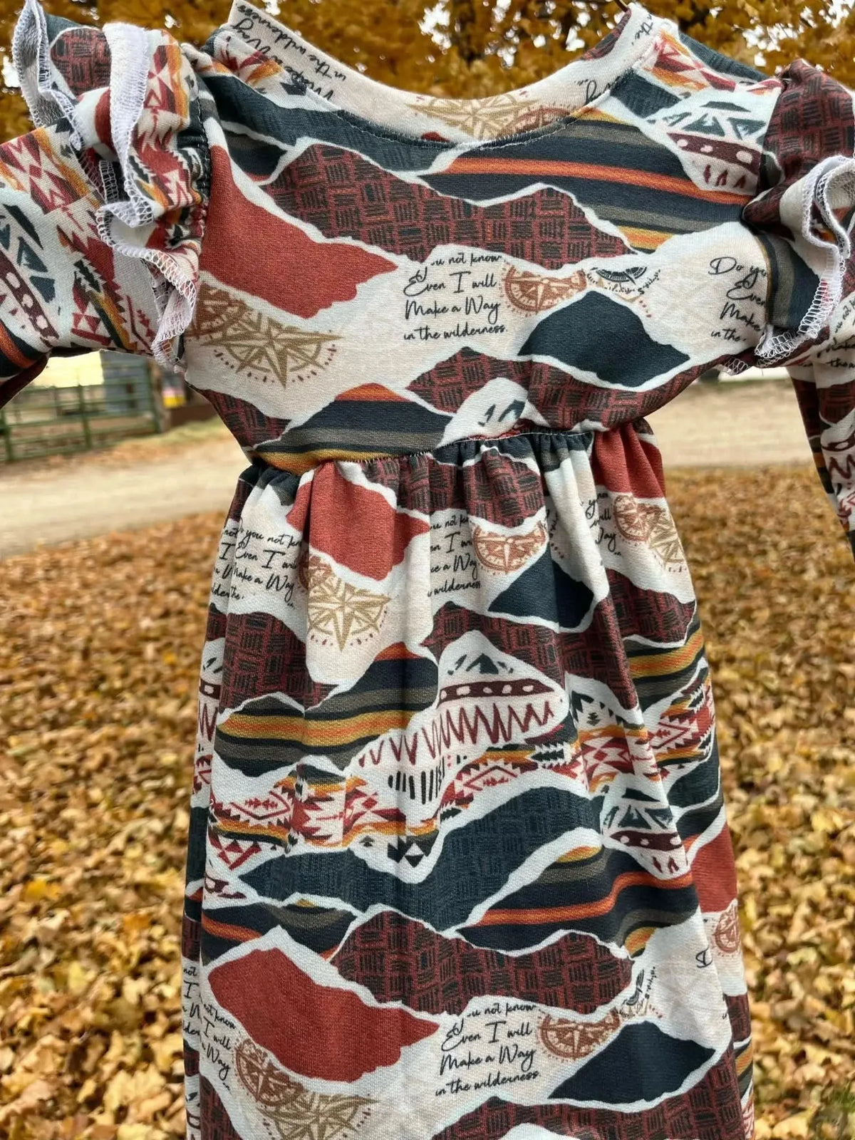 Long-sleeve dress made from WayMaker faith-based print fabric with autumn colors and ruffles.