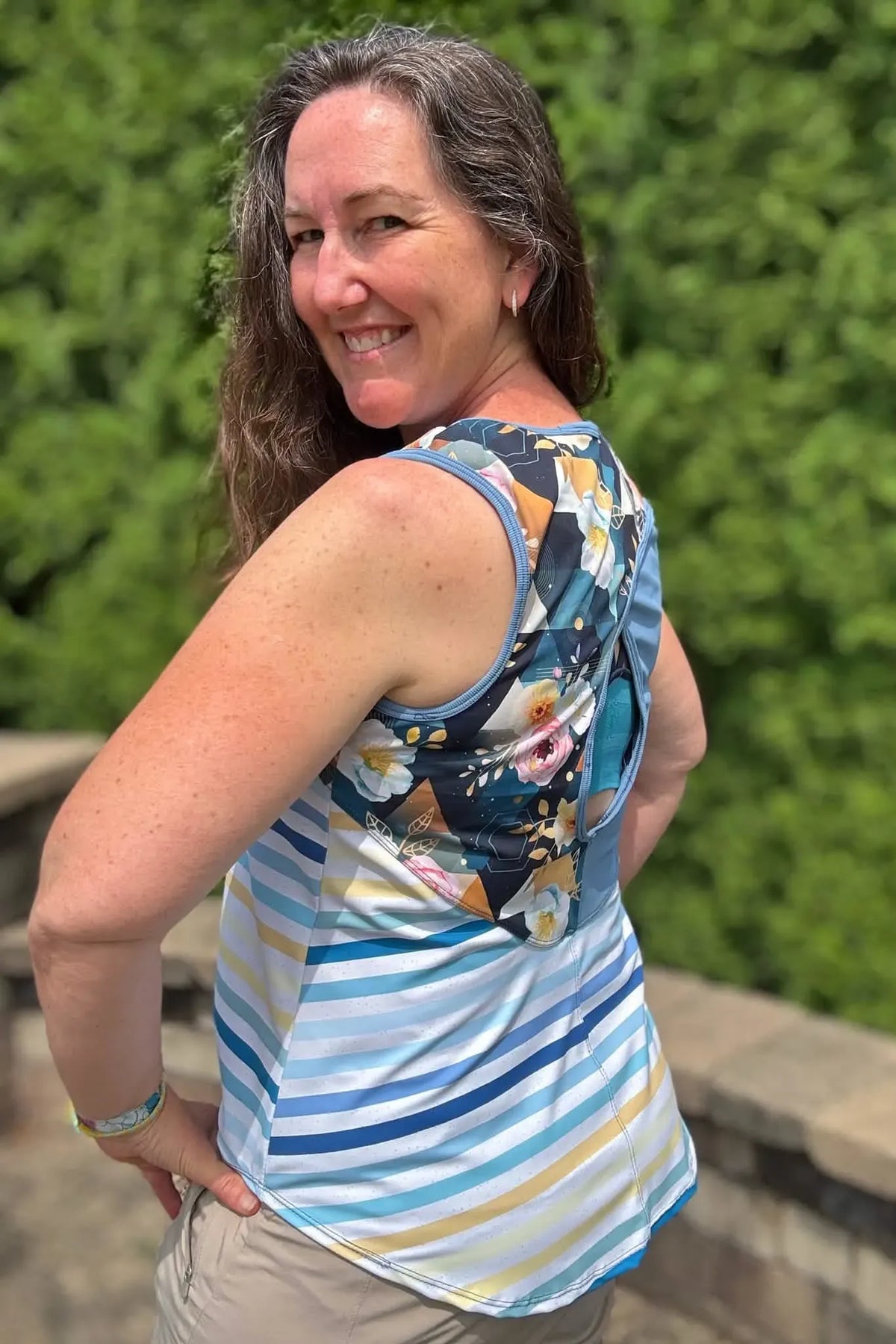 A woman models a top with a striped body and a floral back panel.