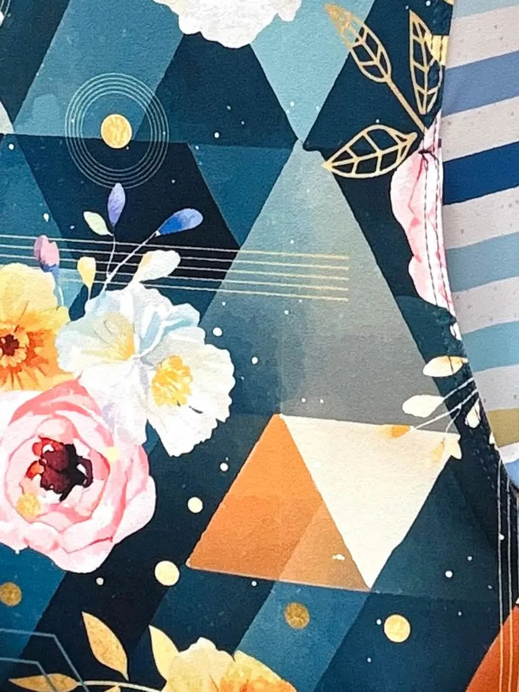 A person wearing a garment with a floral and geometric pattern.