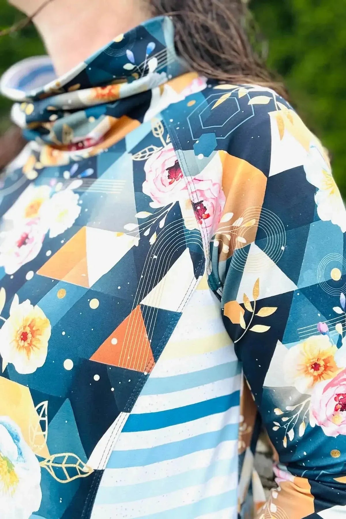 Dark teal geometric floral sewing fabric with abstract triangles, roses, and stars.