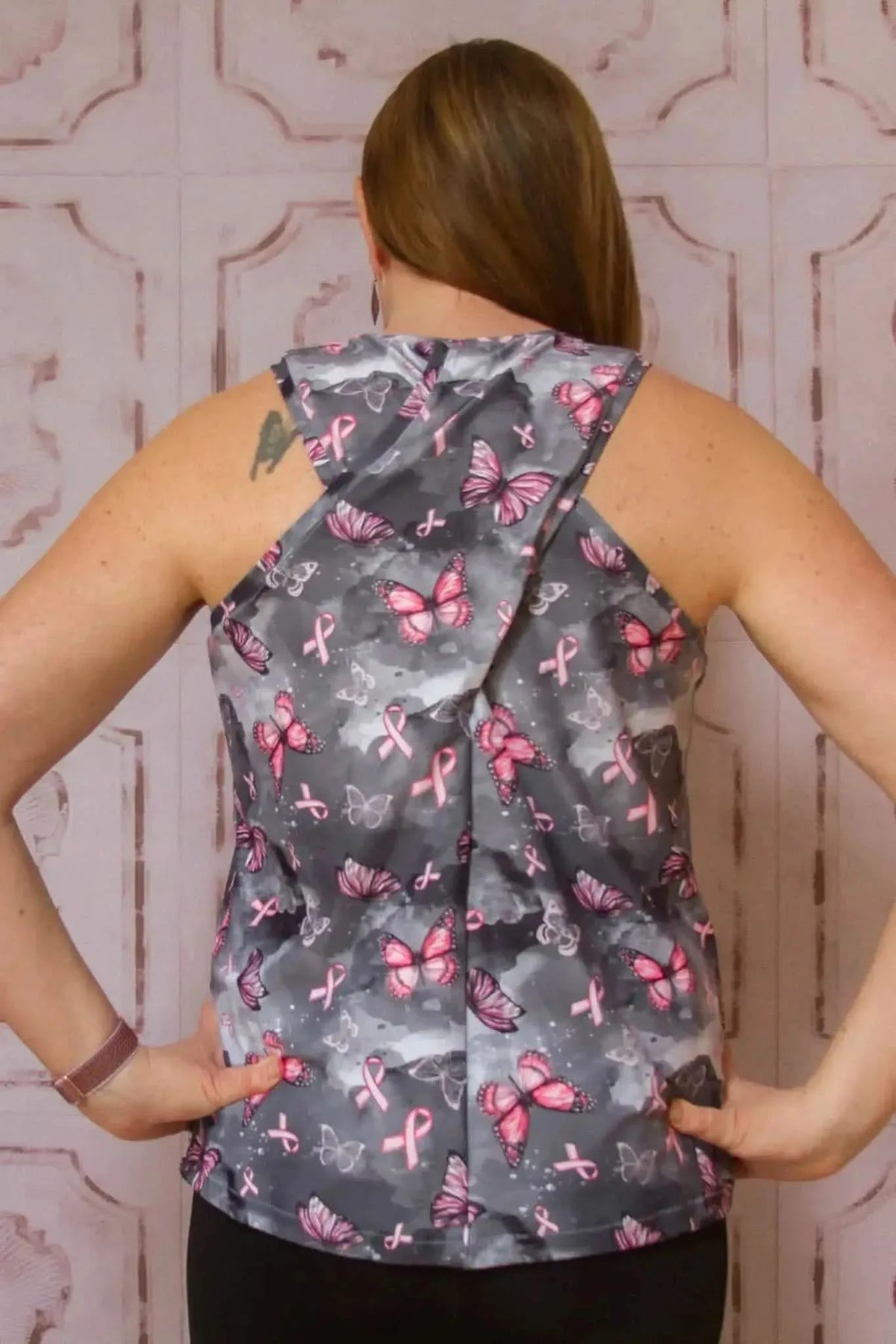 Back view of a sleeveless crossover top made from pink ribbon butterfly print fabric.