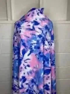 A bolt of bubblegum tie-dye fabric with vibrant pink and blue swirls.