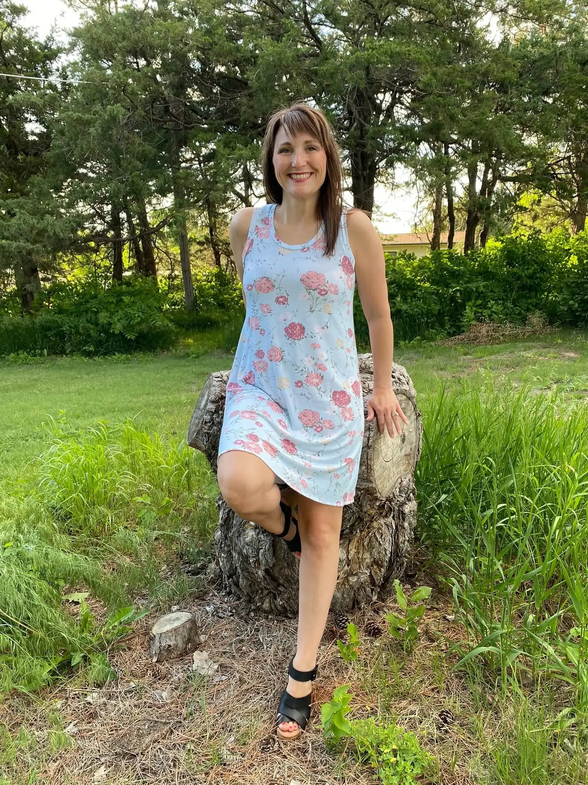 Blue fabric with pink floral print, shown as a sleeveless dress on a model outdoors.