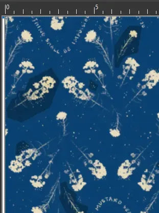 Blue fabric with scattered white mustard seed flowers and text.
