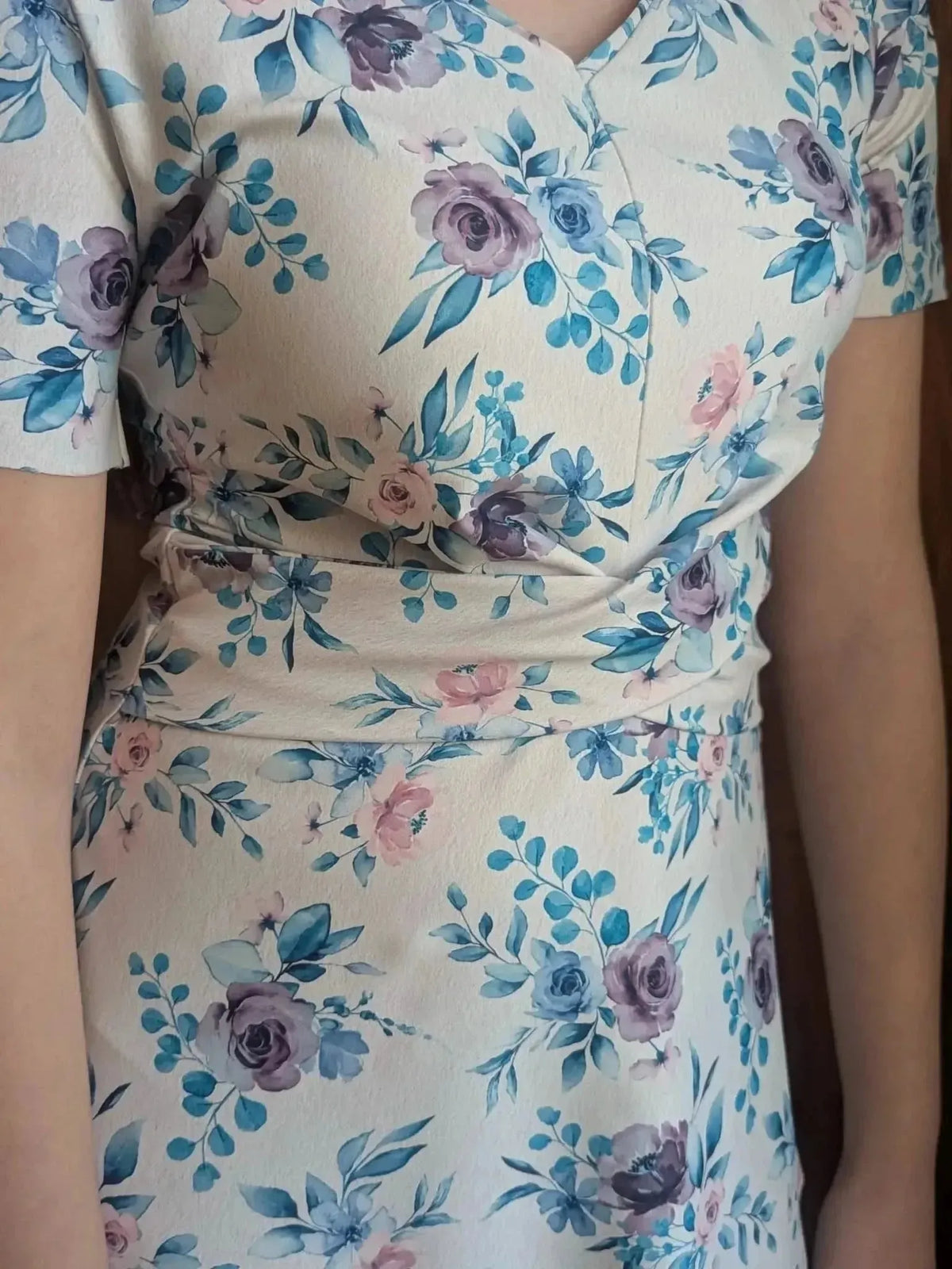 Blue watercolor floral print fabric with purple and pink roses on a light background.