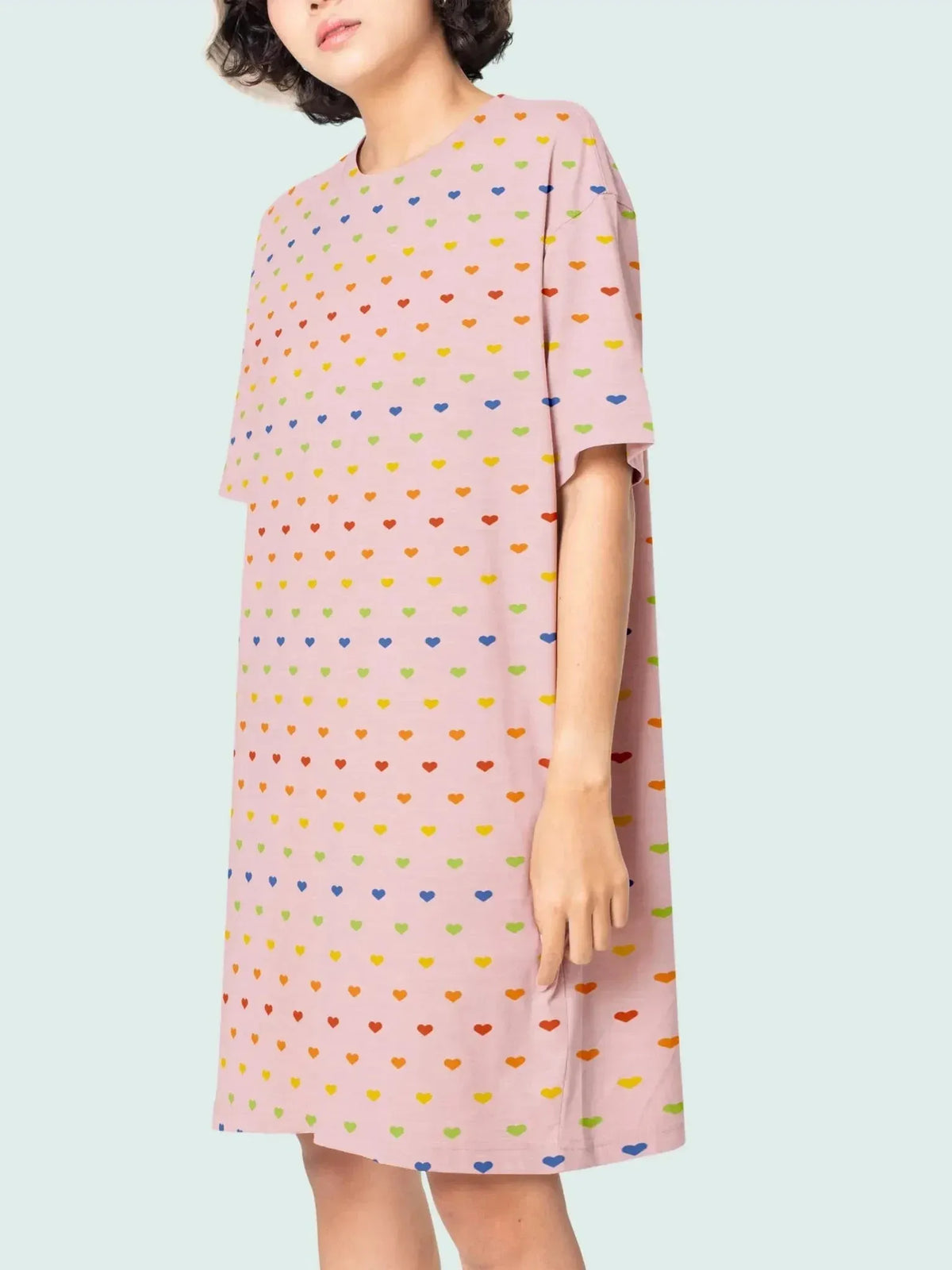 Pink fabric with scattered rainbow-colored heart patterns from Rachel Getz Designs.