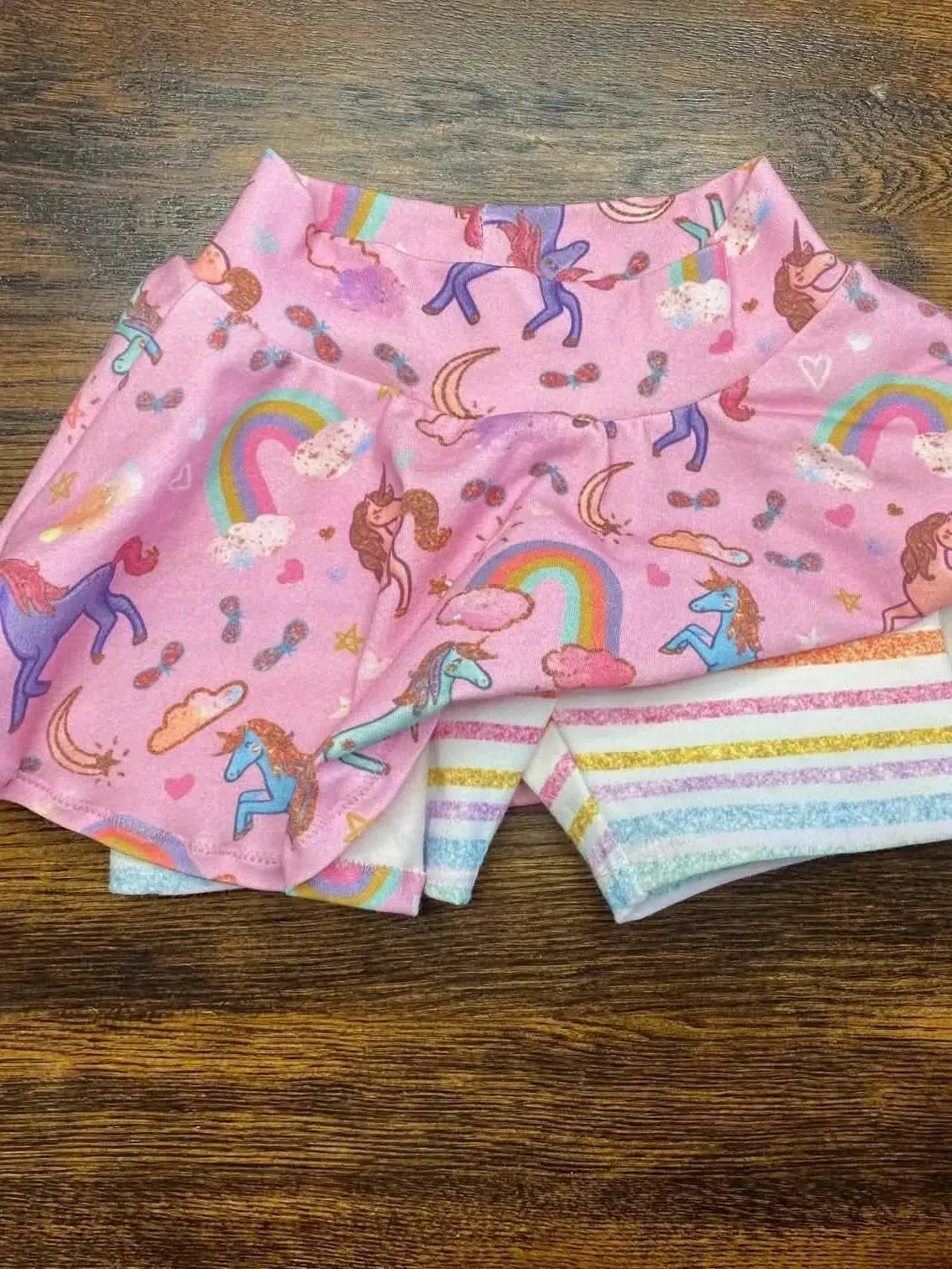Pink unicorn sparkle print fabric with unicorns, rainbows, and stars on a pink background.