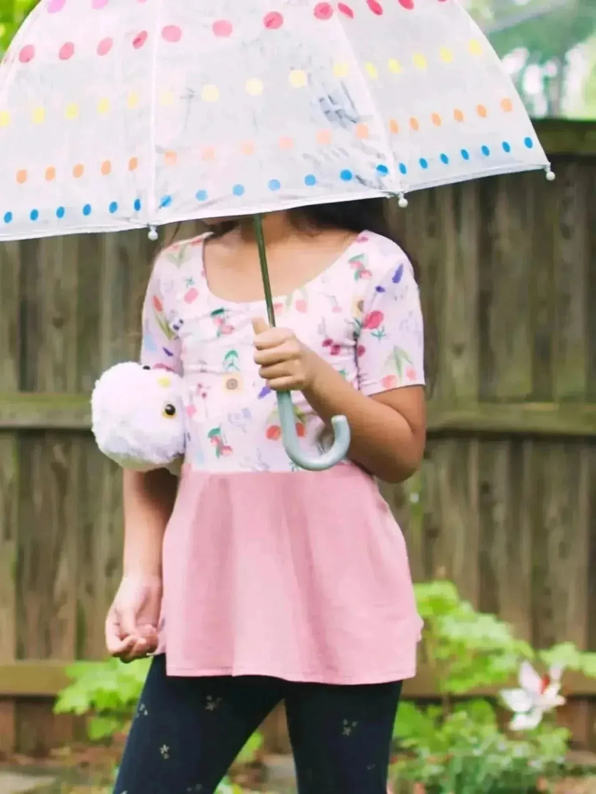 Pink floral fabric with butterfly garden theme, shown in a sewn dress.