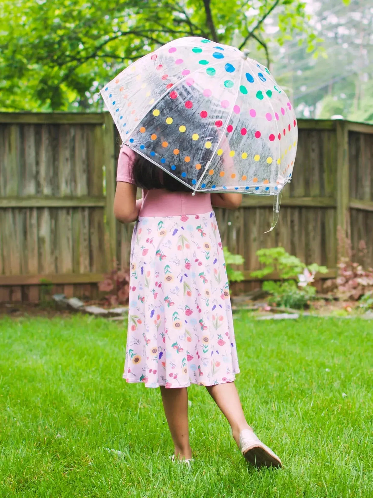Pink floral fabric with butterfly garden theme on a white background.