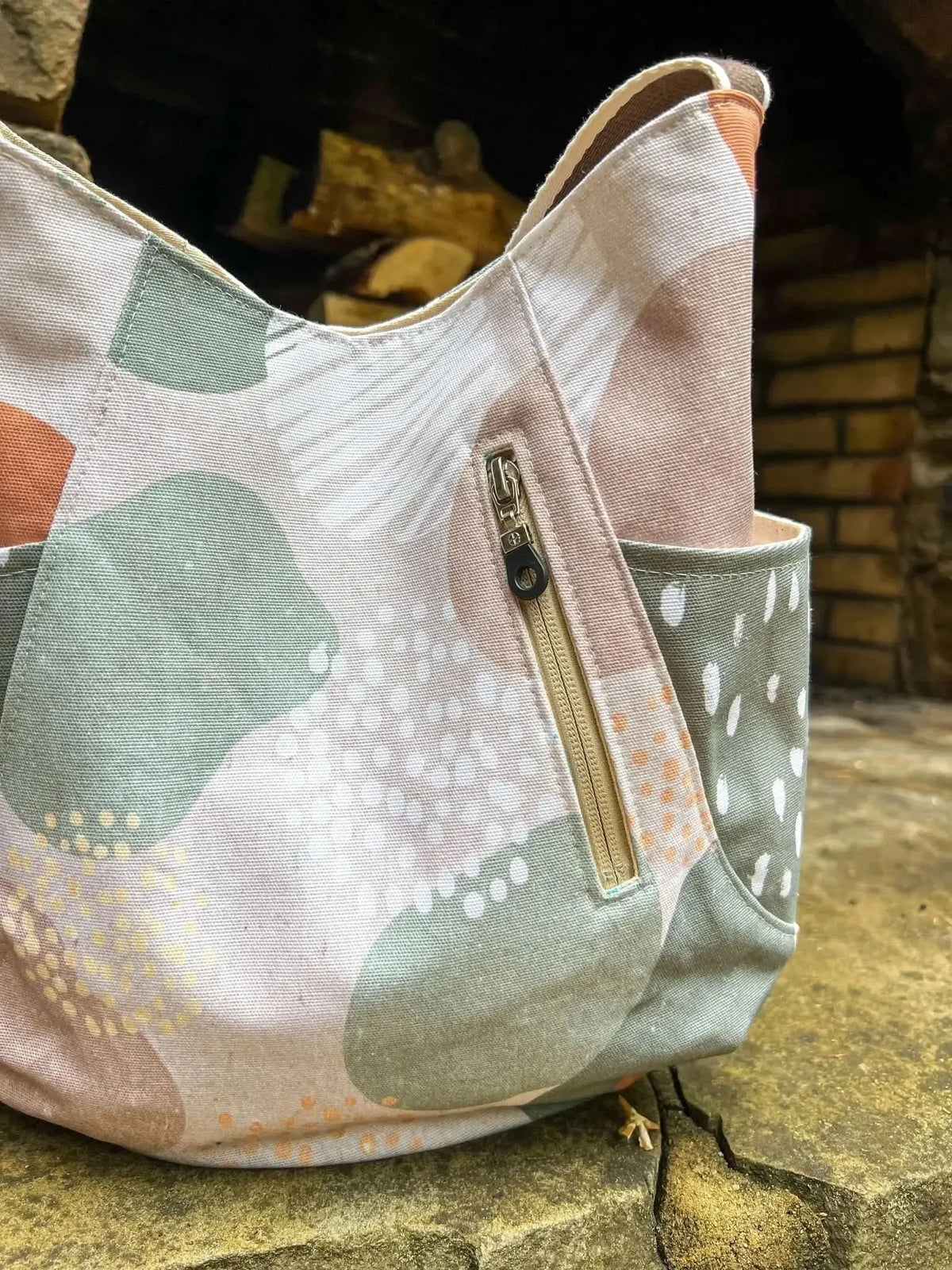 A fabric bag with a modern forest pattern in green, brown, and white.