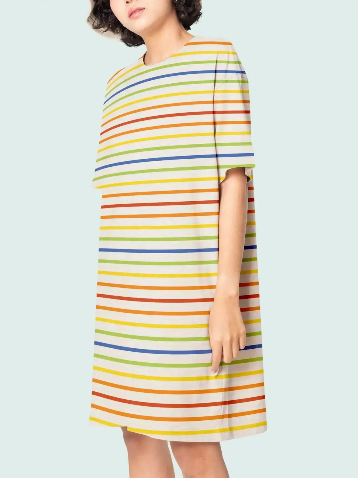A person models a cream-colored dress with horizontal rainbow stripes.