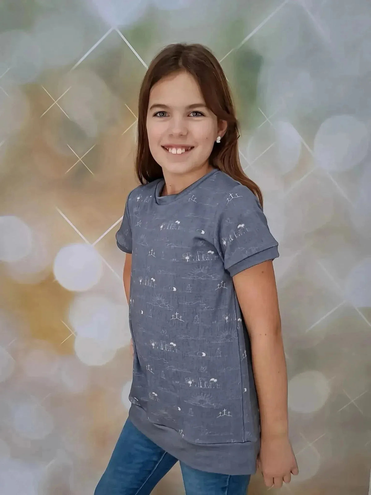 Girl wearing a gray sweatshirt made from sky blue Resurrection Story print fabric.