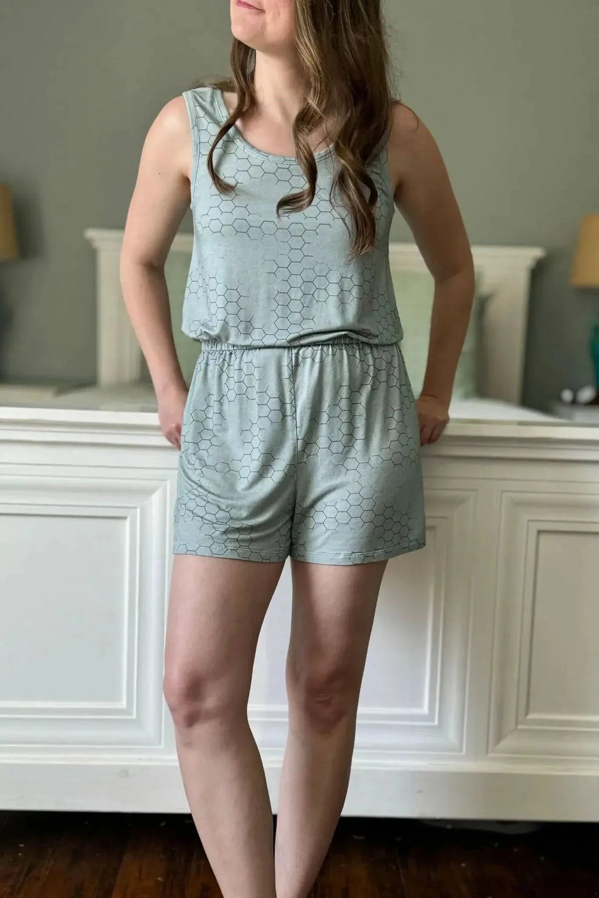 A woman models a light green honeycomb-patterned tank top and shorts set.