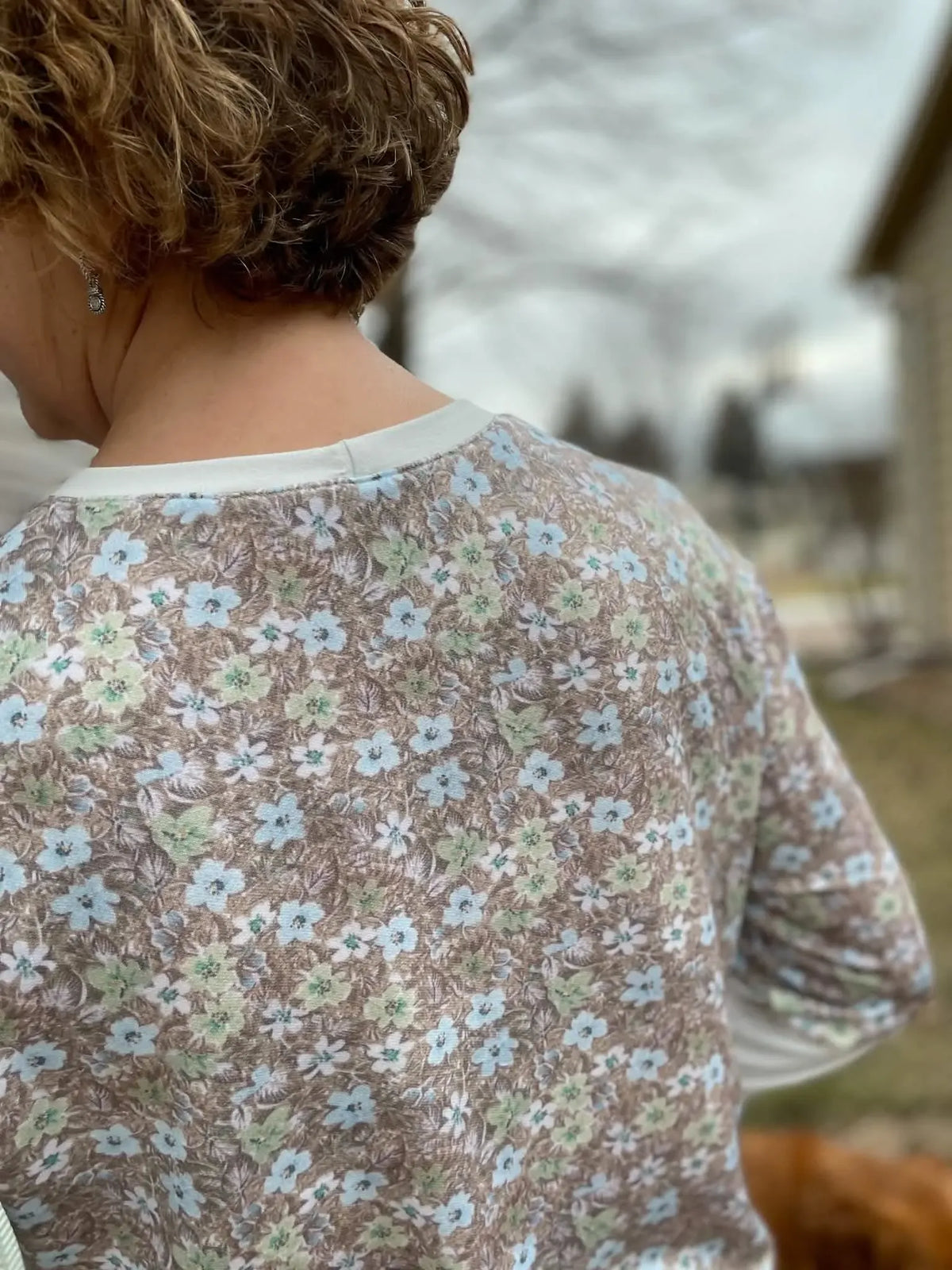 Brown floral print fabric on a person's back.