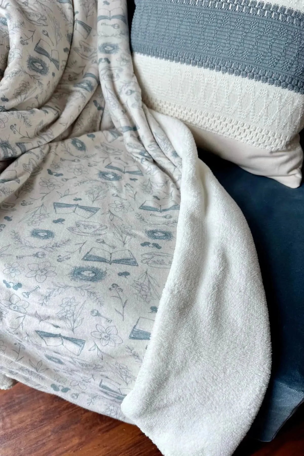 Blue floral toile print fabric with geometric patterns in soft blue tones.