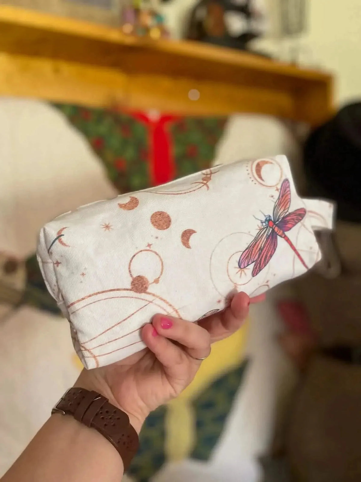 White fabric with celestial moons, circles, and pink dragonflies print.