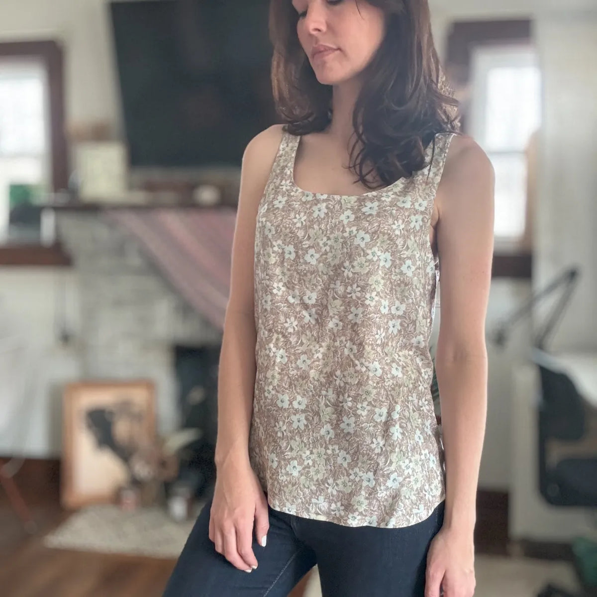 Brown wallpaper leaves fabric on a sleeveless top worn by a woman.