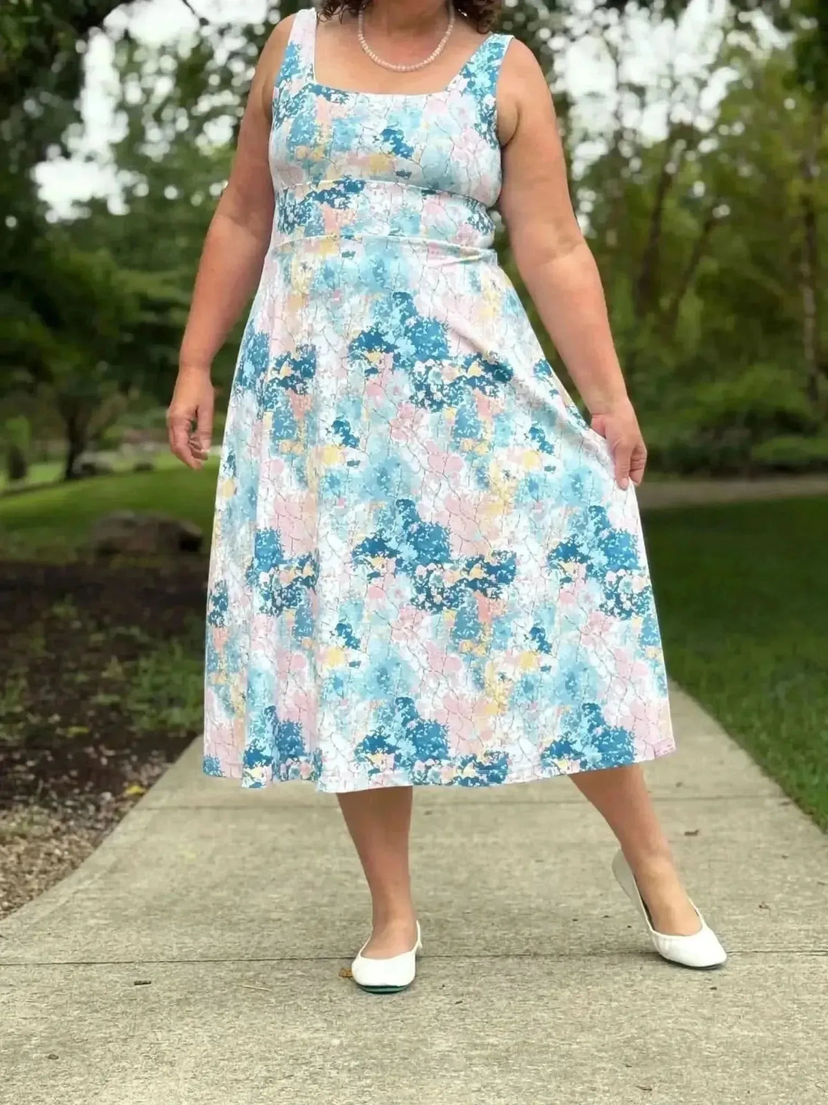 Blue and pink abstract floral fabric with faith-based print, shown as a sleeveless midi dress.