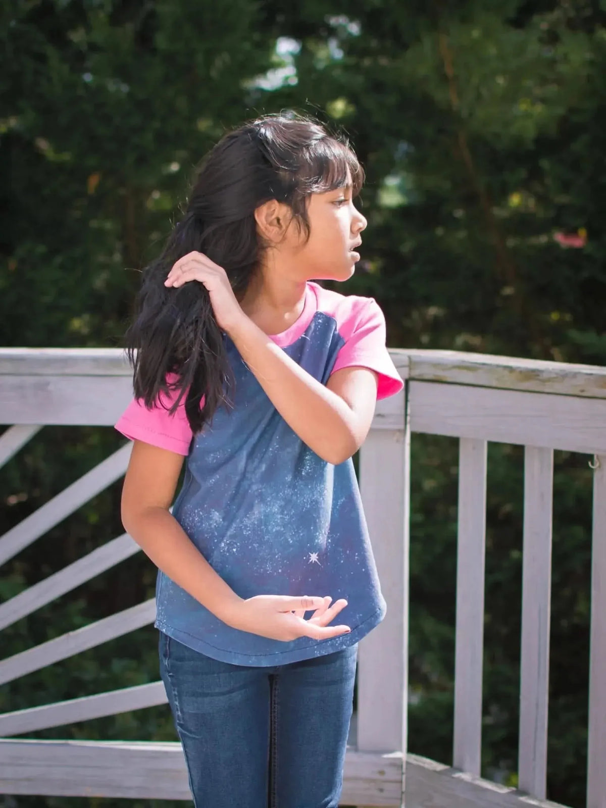 Girl in blue and pink baseball tee with Star of Bethlehem fabric print, posing outdoors.