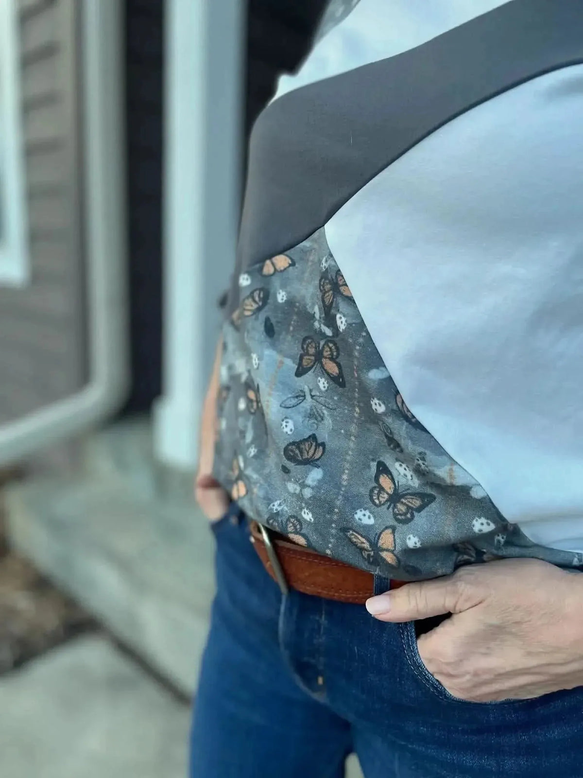 Gray fabric with a subtle monarch butterfly print pattern.